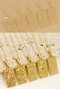 Detail of 18K gold plated stainless steel tarot pendants with zodiac and celestial engravings