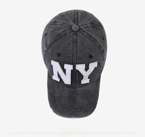 Detailed top view of a washed grey denim baseball cap with white NY embroidery