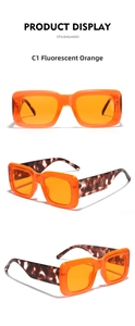 Detail view of neon orange square sunglasses with tortoiseshell temples and UV400 marking