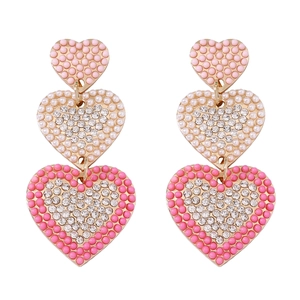 Detail of gold heart earrings with pink beads and crystals in a triple-layered design