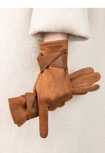 Gants tactiles en daim marron avec bride en cuir portés sur une manche de manteau