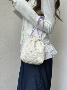 Macro shot of floral quilted cotton makeup bag with purple drawstring and texture details