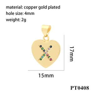 Macro detail of copper gold-plated heart pendant with colorful zircon stones letter X