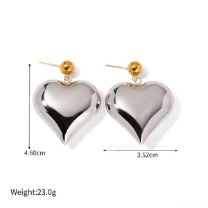 Detailed view of large gold and silver heart earrings with 4.6cm height dimensions