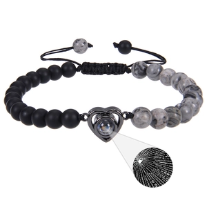 Detail of heart projection stone showing 100 languages of I Love You in a beaded bracelet