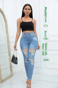 Dettaglio dei jeans azzurri a vita alta con cintura irregolare ed effetto denim strappato
