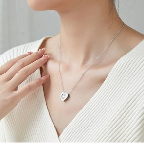 Detailed close-up of a silver heart pendant necklace with shimmering crystal accents