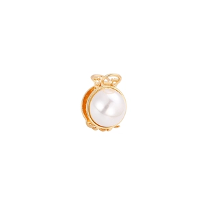 Detail of golden metal hair claw clip featuring large round white pearls on a white background