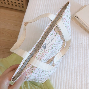 Gros plan détaillé d'un sac en coton à fleurs roses avec fermeture éclair sécurisée