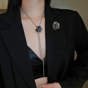 Detail of elegant black rose necklace and brooch set with sparkling rhinestones on model