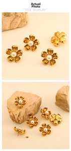 Detail view of gold flower earrings with central pearl and small pearl petals