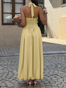 Detail of the cross strappy back design on a light yellow elegant long maxi dress