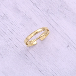 Top view of double-layered gold adjustable ring on a minimalist textured surface