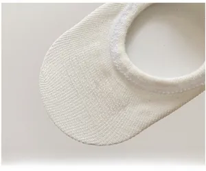 Detail of white cotton no-show socks featuring anti-slip silicone strips on the inner heel