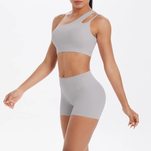 Grey one-shoulder yoga set showing high-waist shorts and cutout sports bra on a model