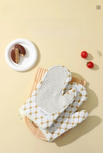 Detail of floral oven mitt with silicone non-slip pad on a rustic wooden board