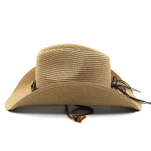 Detail of woven straw cowboy hat featuring brown decorative band and adjustable chin strap