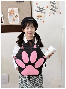 Girl wearing a cute black backpack featuring a pink cat paw design in a lifestyle setting