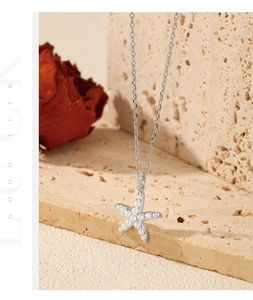 Gros plan du pendentif étoile de mer en argent S925 avec perles et éclats de zircon