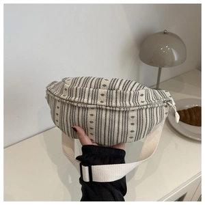 Detail of black and white striped corduroy bag with adjustable strap and zipper closure