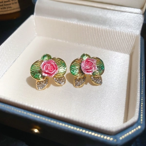 Detail of pink floral earrings with green enamel leaves in a premium jewelry box