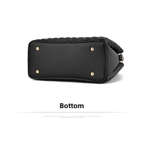Detail view of the black quilted leather bag bottom with golden metal protective feet
