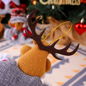 Detail of a handmade elk hanging ornament on a Christmas tree with cozy warm lighting
