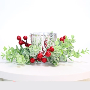 Detail of Christmas candle ring with red berries, green leaves and silver mercury glass