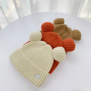 Detailed knit texture of bear ear beanies in cream, orange, and brown colors