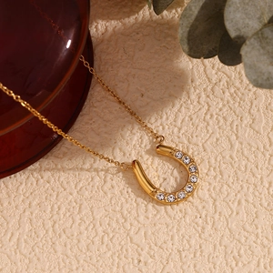 Macro view of 18K gold plated horseshoe U-shape pendant necklace with sparkling diamonds