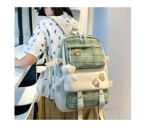 Detail of green and beige plaid canvas backpack with plush bear and cartoon badges