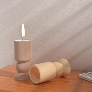 Modernes geometrisches Keramik-Kerzenhalter-Set mit brennender Kerze auf Holztisch
