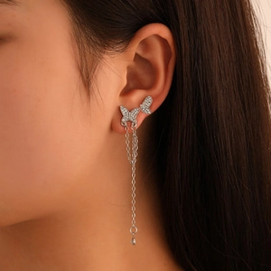 Detail of silver butterfly tassel earrings with rhinestones on a female model