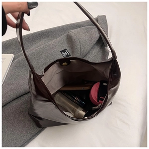 Top-down view of spacious interior and magnetic closure on dark brown patent leather tote