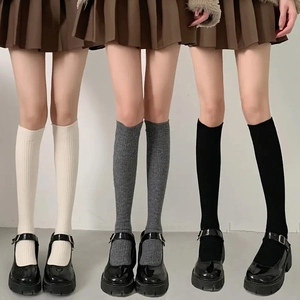 Three pairs of knitted over-the-knee high socks in cream, dark grey and black colors
