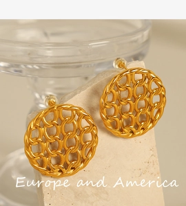 Close-up of golden disk earrings with intricate hollow woven chain texture on stone