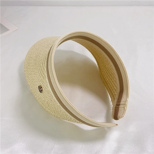 Detail of straw woven visor featuring elastic striped band and gold metal M logo badge