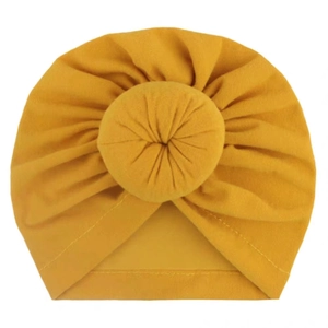 Adorable mustard yellow baby donut turban hat with soft pleated texture on white background