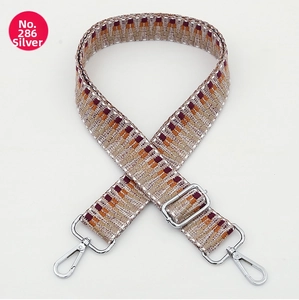 Detail of bohemian geometric woven bag strap with silver hardware and adjustable length