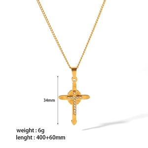 Détail d'un collier pendentif croix en or de 34mm avec diamants sur fond blanc