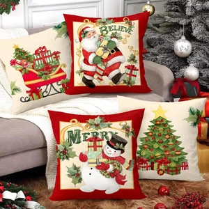Set of four festive Christmas pillow covers with Santa and snowman in a cozy interior