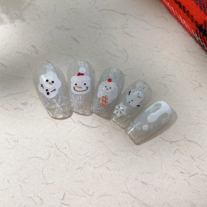 Winter themed embossed snowflake and snowman nail art stickers on a set of five glitter tips