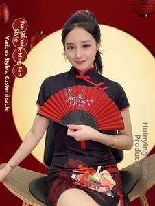 Detail of red folding fan with white plum blossom patterns and a red silk tassel