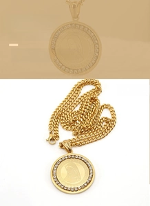 Close-up of 18K gold plated Virgin Mary pendant with sparkling rhinestones and Greek key border