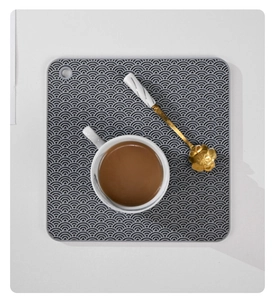 Close-up of a grey silicone pot mat with a wave texture, featuring a handy hanging hole