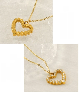 Detail of gold heart pendant with sparkling white zircons and wavy texture finish