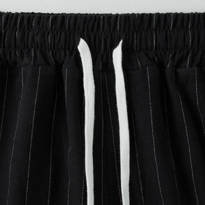 Dettaglio dei pantaloni da spiaggia in lino da uomo con elastico in vita e coulisse bianca