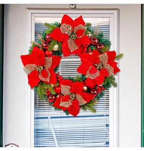 Close-up of red poinsettia and golden glitter ornaments on a green Christmas wreath