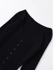 Close-up of black ribbed knit midi dress showing deep V-neck and delicate small buttons
