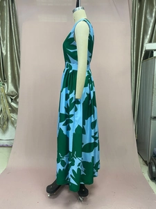 Detail of tropical leaf print sleeveless maxi dress showing A-line silhouette and drape